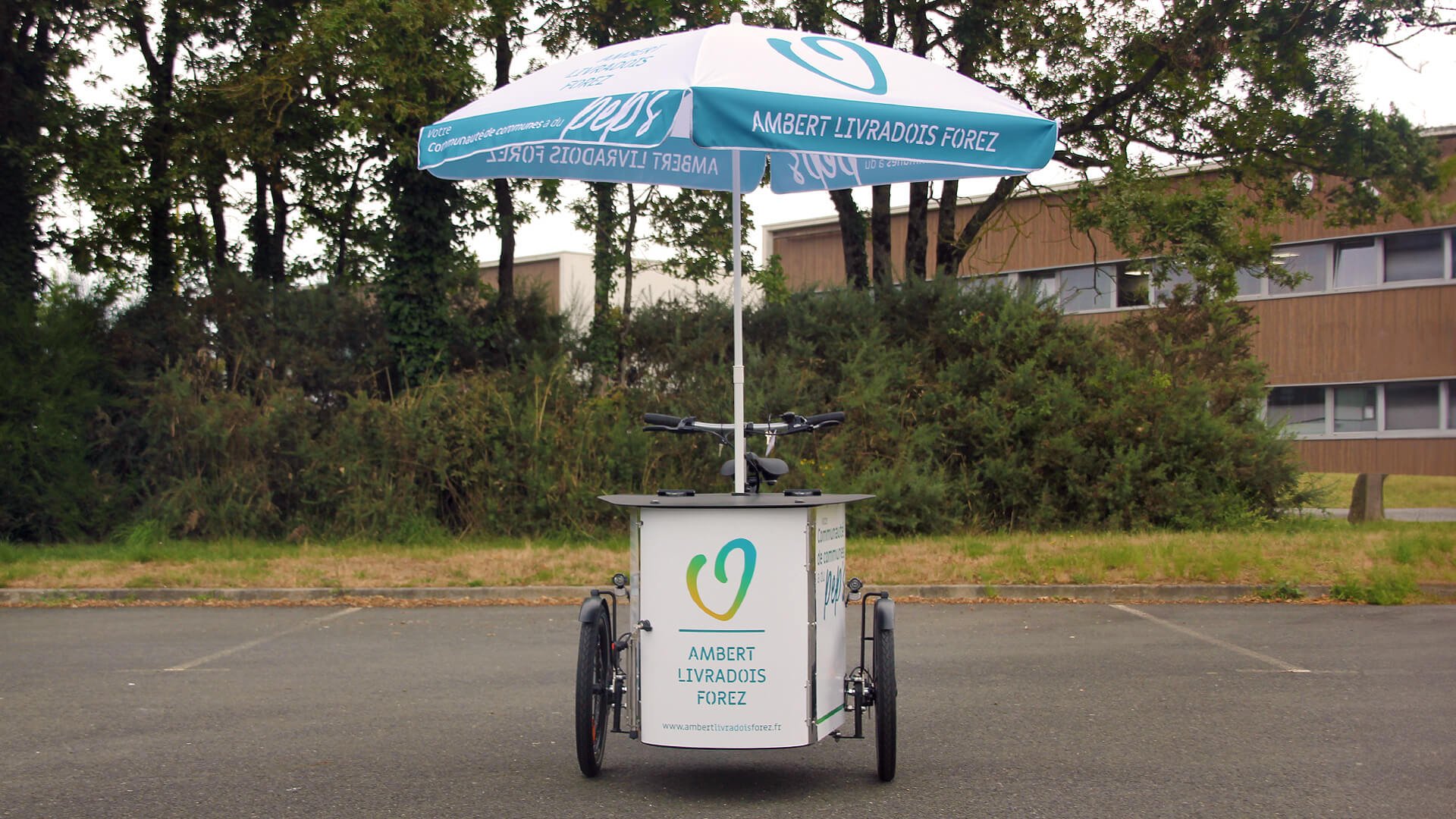 Un NIHOLA CARGO XL avec parasol aux couleurs de la communauté de communes Ambert Livradois Forez (Puy-de-Dôme)
