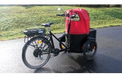 Equipé d'une protection pluie, d'un rétroviseur, d'un banc avec coussin et ceinture de sécurité