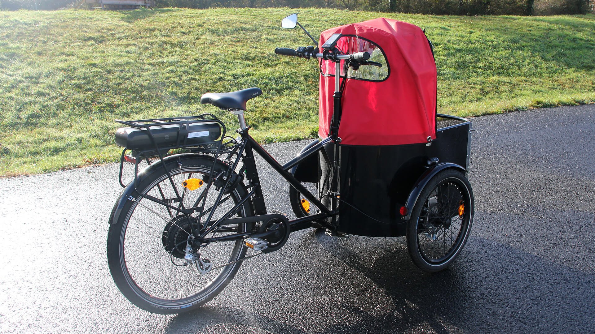 Equipé d'une protection pluie, d'un rétroviseur, d'un banc avec coussin et ceinture de sécurité
