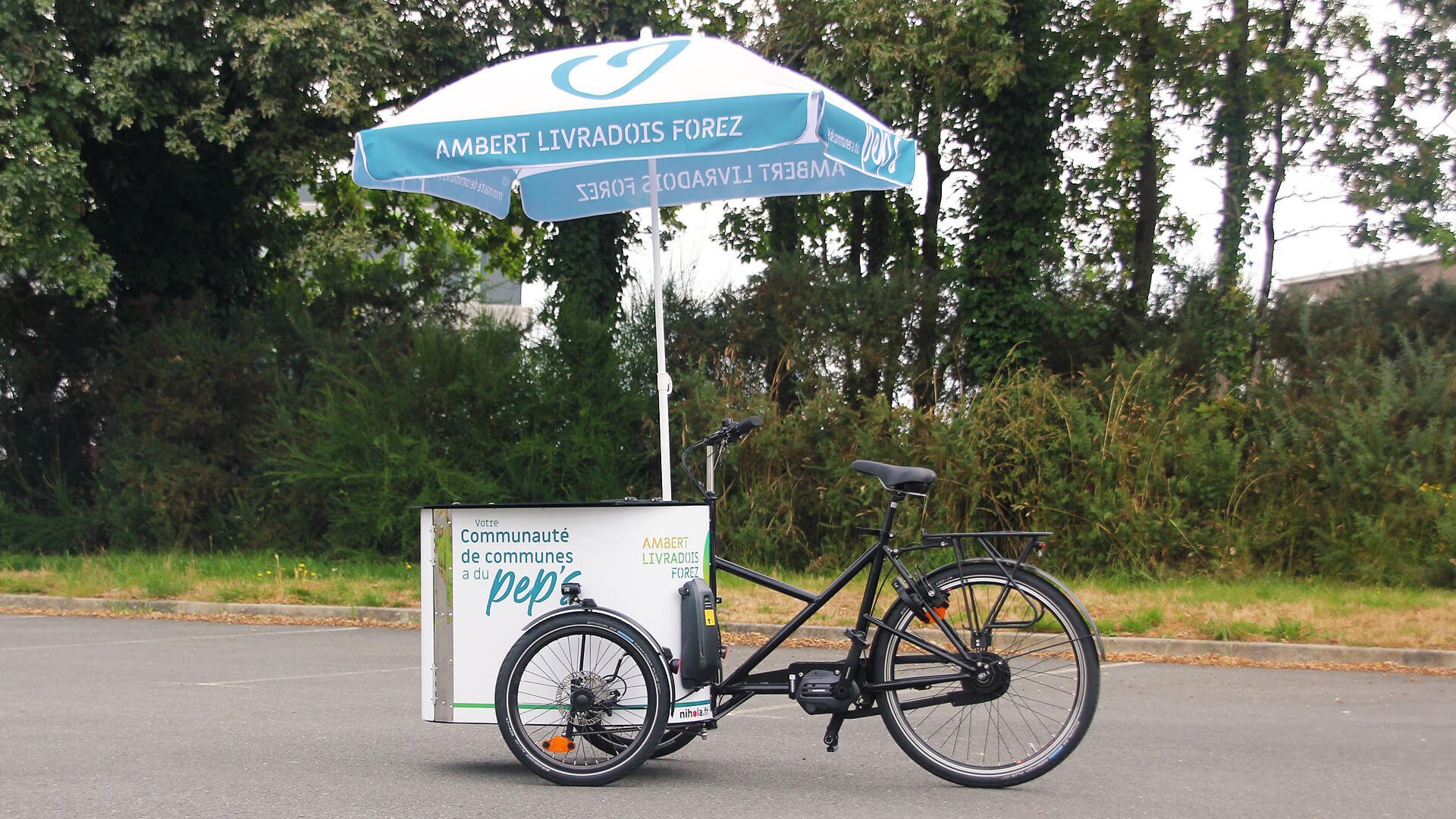 Un NIHOLA CARGO XL avec parasol aux couleurs de la communauté de communes Ambert Livradois Forez (Puy-de-Dôme)